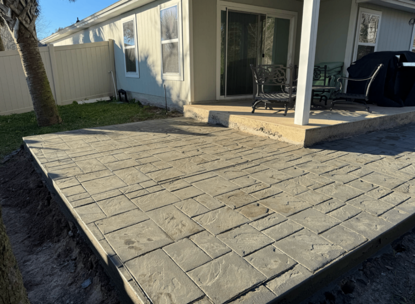 finished broom-textured concrete patio behind a Columbus home with tooled edges